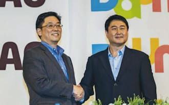 記者会見で経営統合を発表するダウムの崔社長(左)とカカオの李共同代表理事（26日、ソウル）