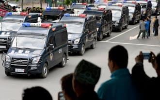 ウルムチ市の中心部をパレードする警察車両（23日、中国新疆ウイグル自治区）=共同