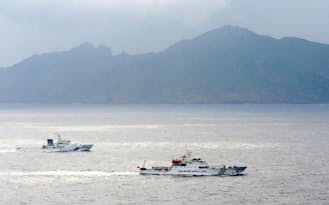 尖閣諸島周辺の領海内を航行する中国の海洋監視船（手前）と海上保安庁の巡視船（2013年4月）