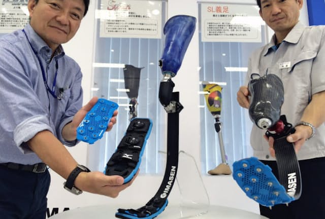 今仙技術研究所の後藤氏(右)とミズノの宮田美文氏(左)が開発した義足用スパイクは、足部分に装着して使用する
