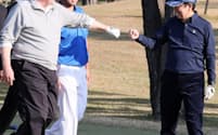 ゴルフコースでトランプ米大統領(左)と拳を合わせる安倍首相。松山英樹選手(中)も一緒にラウンドした（5日、埼玉県川越市の霞ケ関カンツリー倶楽部）=内閣広報室提供
