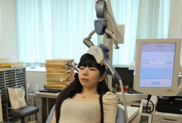 経頭蓋磁気刺激（TMS）の治療イメージ（写真は健常者によるモデル撮影、鬼頭伸輔氏提供）