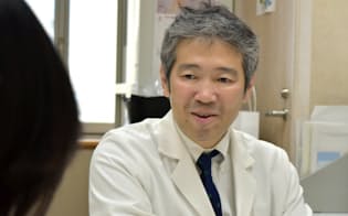 小峰さんの話を聞く国立がん研究センターの清水研医師（4月、東京・中央）
