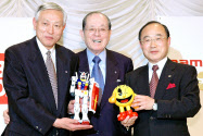 会見で互いのキャラクターを手にするナムコの高木副会長（左）と中村会長（中）、バンダイの高須社長（2005年5月）