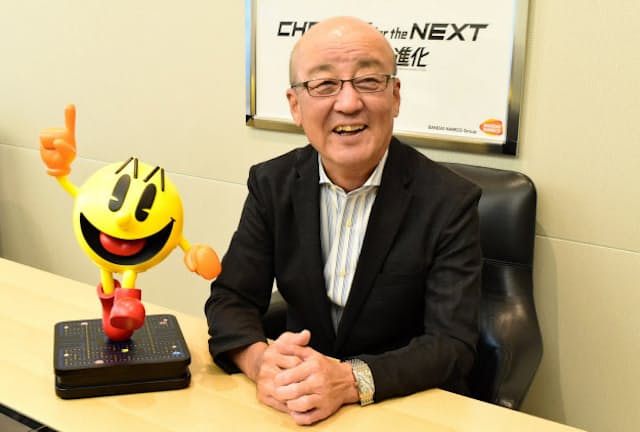 ナムコが生んだ大ヒットゲーム「パックマン」のキャラクターを前に微笑む石川氏