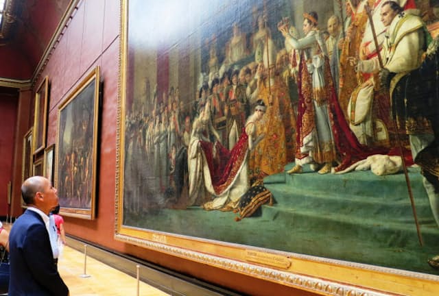 ルーヴル美術館でダヴィッドが描いた「ナポレオン一世の戴冠式と皇妃ジョゼフィーヌの戴冠」を鑑賞する佐藤