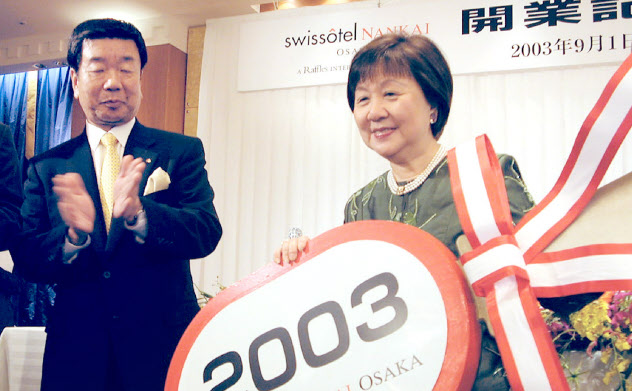 「スイスホテル南海大阪」開業時、ラッフルズのジェニー・チュア会長(当時、右)に鍵の模型を渡す(2003年) 「スイスホテル南海大阪」開業時、ラッフルズのジェニー・チュア会長(当時、右)に鍵の模型を渡す(2003年)