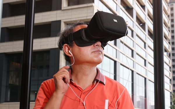 ゴーグル、スマホ、イヤホンがあればライブを仮想現実（VR）で楽しめる（東京・大手町）=三浦秀行撮影