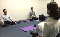佐渡医師(左)の指導で、瞑想して今の心の状態を見つめる（現在はオンライン開催）=東京都新宿区の慶応大学ストレス研究センター