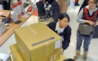 外国人観光客が購入した30個の福袋を運ぶ百貨店の従業員（1日、東京都豊島区の西武池袋本店）