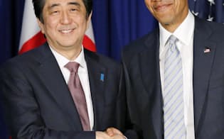 会談で握手する安倍首相とオバマ米大統領（19日、マニラ）=共同
