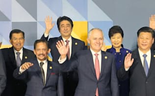 手を振る安倍首相（左から3人目）ら（19日、マニラ）=代表撮影・共同
