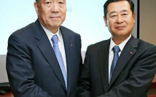 経営統合の発表会見で握手する東洋製缶GHDの中井社長(左)とホッカンHDの工藤社長（25日午後、東京都中央区）