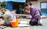 地震で姉が亡くなり、住んでいた自宅前で手を合わせる妹（14日午前、熊本県益城町）