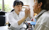 地震の影響で損壊した病院で診察する永田美与さん(左)（13日、熊本県益城町）