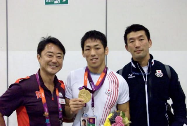 ロンドン大会では金メダルを取ったレスリングの米満達弘選手（中央）の通訳も務めた（左が西川氏）