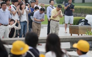 オバマ米大統領の訪問から一夜明けた平和記念公園の慰霊碑前で手を合わせる人たち（28日午前、広島市中区）