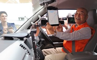 出発前にタブレットを使い、ウーバーのシステムを見せる住民ドライバー（京都府京丹後市で）