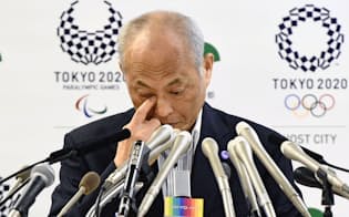 記者会見する舛添知事の後方には20年東京五輪・パラリンピックの大会エンブレムが映っている=共同