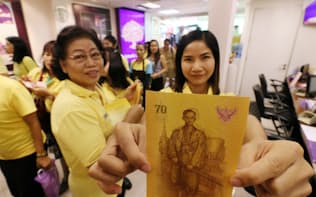 タイのプミポン国王の在位70年を記念して発行された70バーツ紙幣（9日、バンコクの銀行）=写真　浅原敬一郎