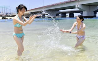 那覇市で、海水浴を楽しむ海外からの観光客=共同