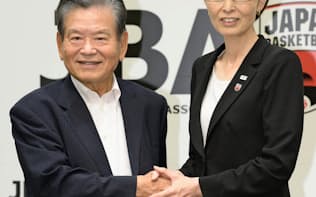 記者会見後、握手する日本バスケットボール協会の川淵三郎前会長（左）と三屋裕子新会長（25日、東京都港区）=共同