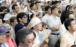東京都知事選で候補者の街頭演説を聞く有権者ら（17日、東京都内）=共同