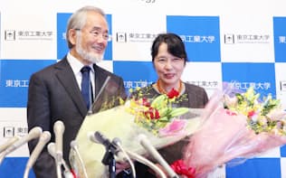 花束を手に笑顔を見せる東工大の大隅良典栄誉教授(左)と妻、萬里子さん（4日午前、横浜市緑区）