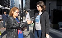 シカゴ市内の投票所近くでチラシを配るアレックス・ニエンチェウスキーさん（29、写真右側）
