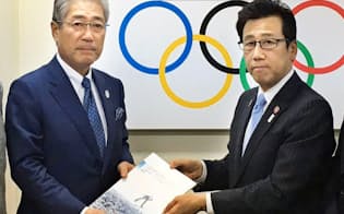 札幌市の秋元市長（右）はJOCの竹田恒和会長に開催提案書を提出した=共同