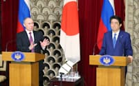 共同記者会見でロシアのプーチン大統領(左)の発言を聞く安倍首相(16日午後、首相公邸)