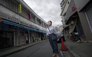 かつてヤミ市が並んでいた横浜の野毛地区で当時の服装で立つ女優の五大路子さん（撮影:森日出夫）