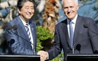　共同記者発表を終え、オーストラリアのターンブル首相（右）と握手する安倍首相=14日、シドニー（共同）