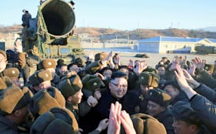 北朝鮮の労働新聞が13日掲載した、ミサイル発射に立ち会った金正恩朝鮮労働党委員長（中央）の写真（共同）
