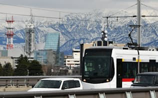 立山連峰を背に走行する富山地鉄の市内電車（2日、富山市）