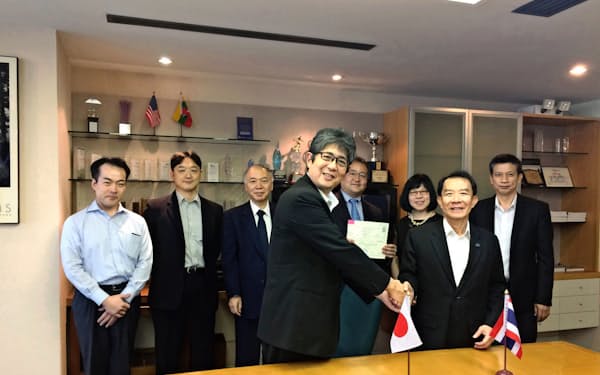 森・浜田松本法律事務所は昨年12月、タイの大手事務所を買収した(調印式でタイ側代表と握手する河井聡弁護士(左)ら)