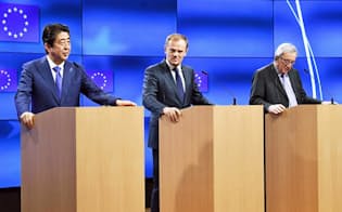 会談を前にトゥスクEU大統領（中央）、ユンケル欧州委員長（右）と共同記者発表に臨む安倍首相（21日、ブリュッセル）=共同