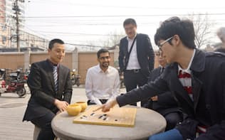 昨年、北京で柯潔九段（右端）からアルファ碁の手について説明を受けるグーグルのピチャイCEO（ディープマインド提供）