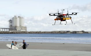 10キロを超える距離を完全自律制御で試験飛行し、海岸線で待つサーファーに飲み物を届ける小型無人機「ドローン」（12日午前、福島県南相馬市の北泉海水浴場）
