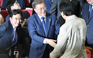 韓国大統領選の投票締め切り後、支持者の前に現れ、笑顔を見せる「共に民主党」の文在寅氏（中央）=9日夜、ソウル（共同）