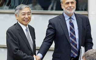 「国際コンファランス」で握手するバーナンキ前FRB議長(右)と黒田日銀総裁（24日午前、日銀本店）
