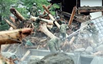 道路の流木や土砂を撤去する自衛隊員（8日午前、福岡県東峰村）