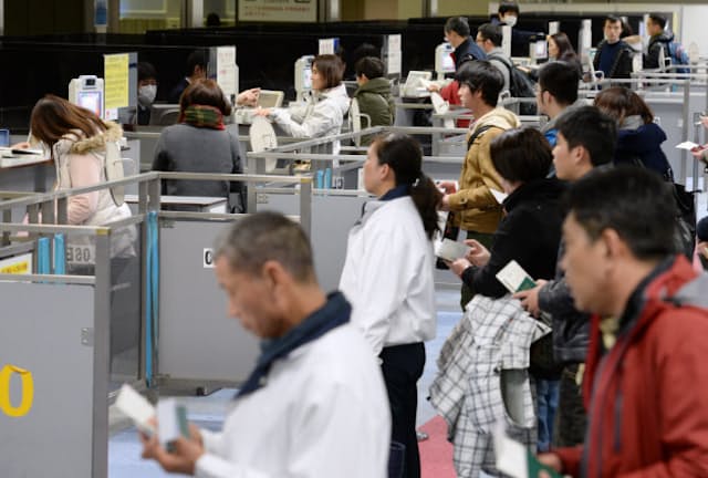 成田空港で入国審査を受ける外国人観光客ら