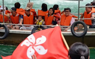 「ルーシャンシャオシン（いってらっしゃい）！」と船着き場のスタッフに見送られ遊覧船で出発する香港からの観光客。大歩危（おおぼけ）峡には連日、外国人観光客を乗せたバスが何台もやってくる（徳島県三好市）