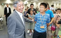 夏休みの子ども見学会で、笑顔で話す黒田総裁(左)=10日、日銀本店