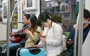 スマートフォンの普及により人々は日常的にネットを通じ情報を収集するようになった（中国・上海）