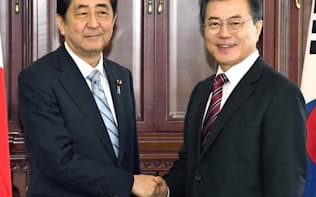 会談前に韓国の文在寅大統領（右）と握手する安倍首相=7日、ウラジオストク（共同）