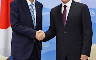 会談前に握手するロシアのプーチン大統領（右）と安倍首相（7日、ウラジオストク）=共同