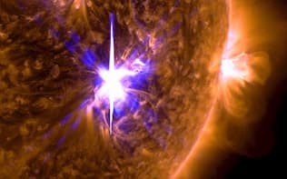 NASAの観測衛星が6日に撮影した、太陽表面で発生した大規模爆発「フレア」（中央）の画像=NASA提供・共同