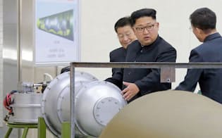 　「火星14」型核弾頭と題された図面の前で「水爆」とみられる物体を視察する北朝鮮の金正恩朝鮮労働党委員長。朝鮮中央通信が3日配信した（朝鮮通信=共同）